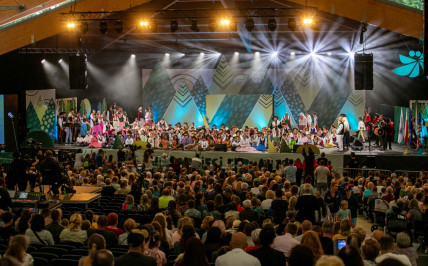 Scena amfiteatru podczas finałowego koncertu Festiwalu, wypełniona dziecięcymi zespołami oraz pełna widownia