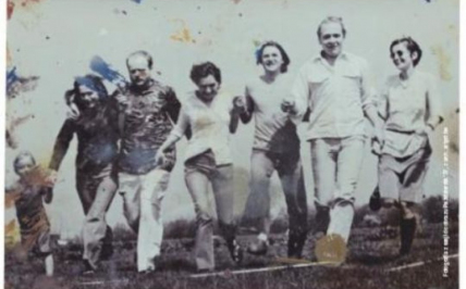 Seven running people holding hands