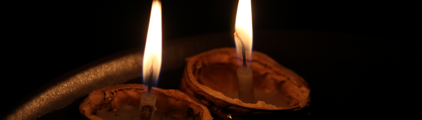 Dwie małe świeczki palą się w łupinach orzecha