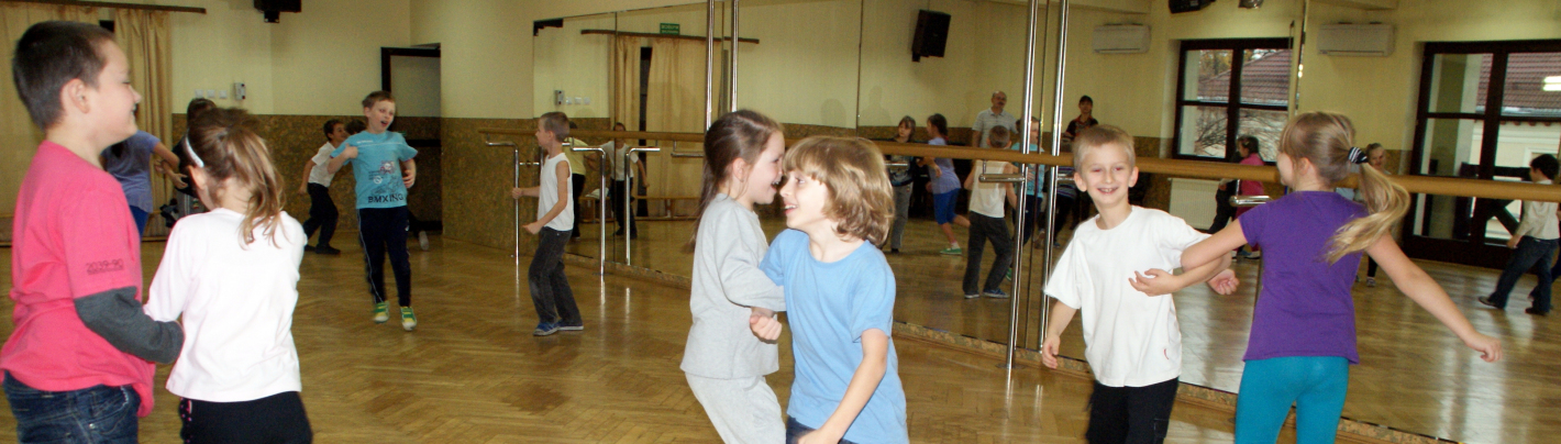 Małe dzieci tańczą w parach w sali tanecznej