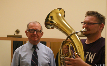 dwóch mężczyzn stoi, jeden gra na tubie