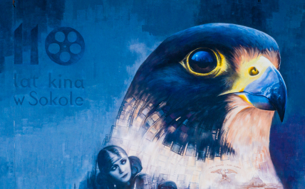 Mural na ścianie bloku, przedstawiający ptaka oraz postaci filmowe