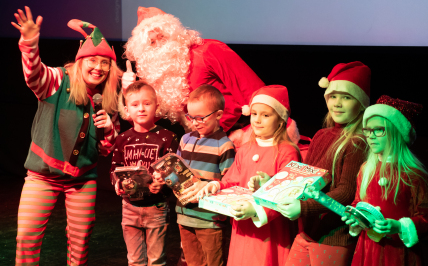 Mikołaj stoi z elfem na scenie