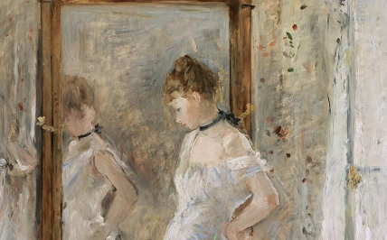 Kobieta w białej sukni stoi przy lustrze
