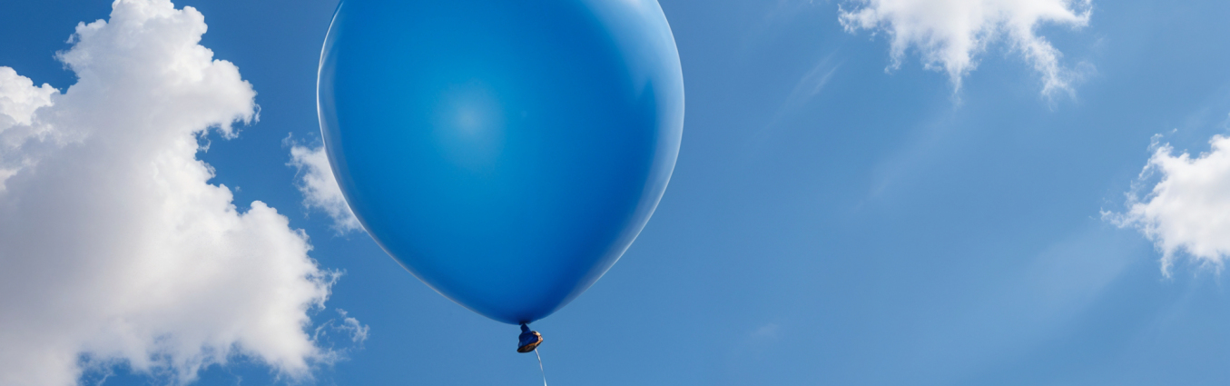 niebieski balonik unoszący się na niebie w otoczeniu chmur