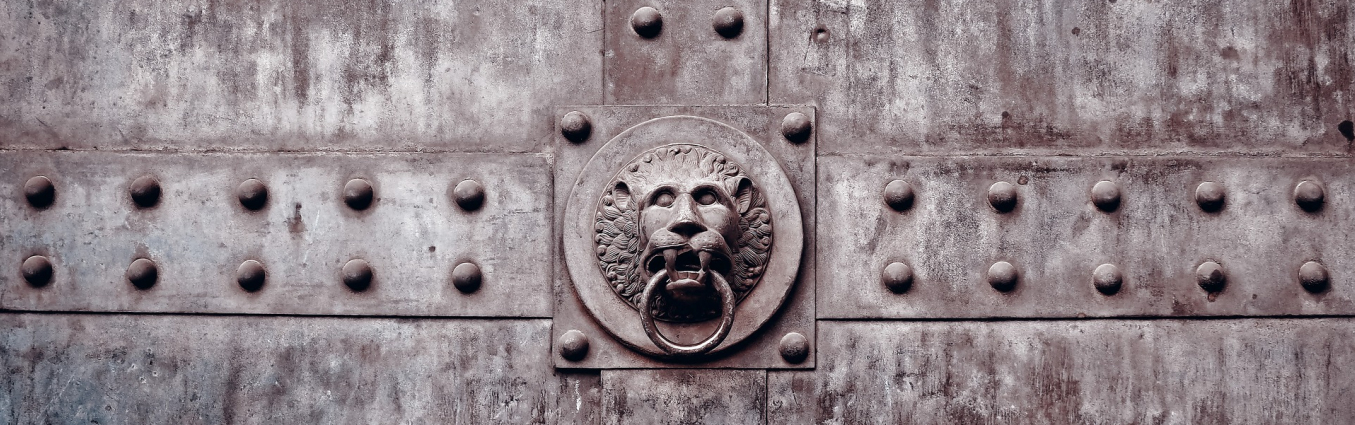Duża metalowa brama z ozdobną kołatką w kształcie lwa