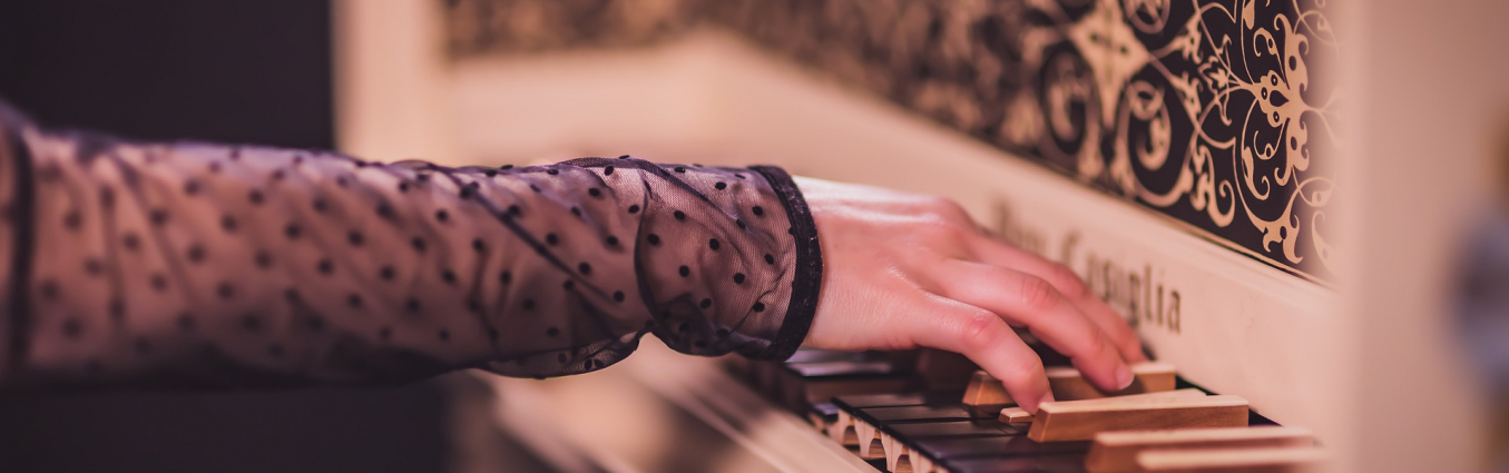 Ręce kobiety oparte o instrument klawiszowy