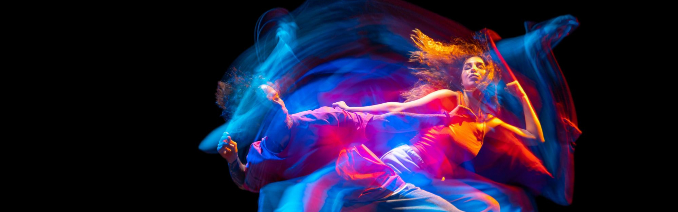 Dynamiczny portret młodego mężczyzny i kobiety tańczących hiphop na białym tle na czarnym tle z mieszanym efektem świetlnym 