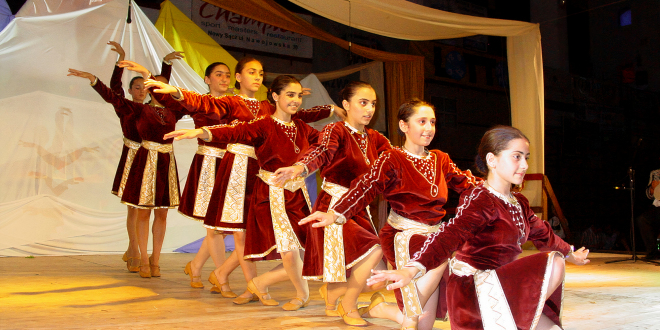 dziewczynki w bordowych sukienkach tańczą na scenie