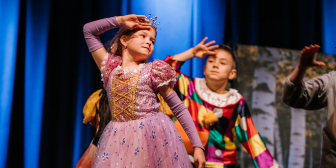 Chłopiec i dziewczynka występują na scenie w baśniowych strojach
