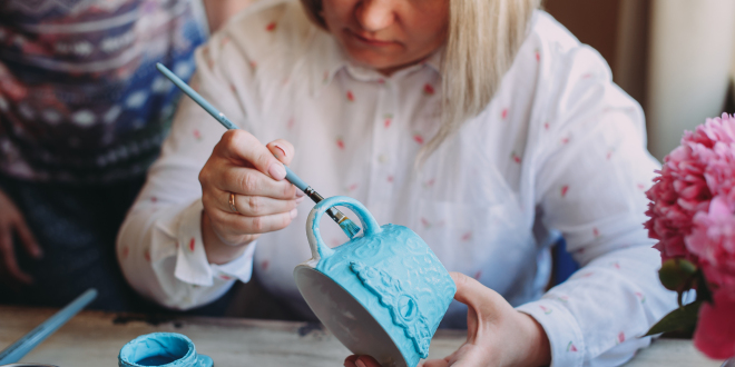 Adobe Stock zdjęcie kobiety malującej filiżankę niebieską farbą