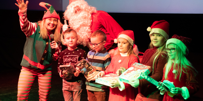 Mikołaj stoi z elfem na scenie
