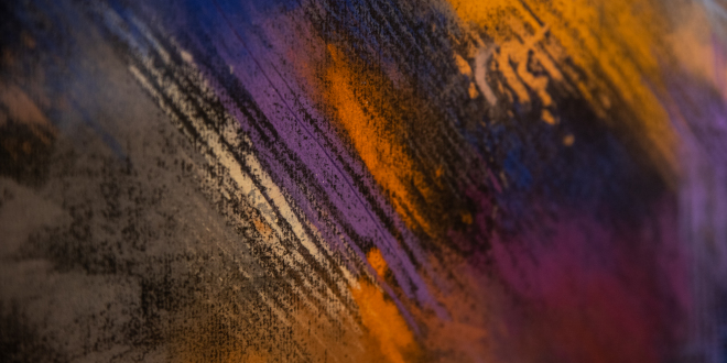 Fragment of an abstract picture. On a black background, diagonal lines made with pastel crayons. Very colorful.