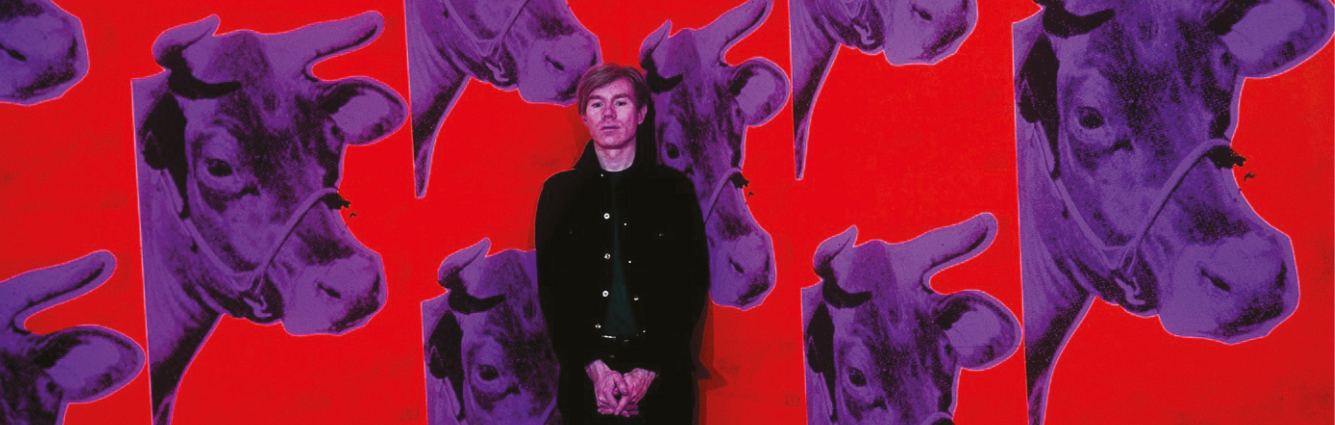 Na tle czerwonej tapety z wielokrotnie powielonym obrazem fioletowej, krowiej głowy stoi mężczyzna, artysta amerykańskiego pochodzenia – Andy Warhol. Mężczyzna stoi prawie na baczność, jego dłonie krzyżują się poniżej pasa. Beznamiętnie wpatruje się w kierunku fotografa wykonującego jego portret. Ubrany jest w czarnego koloru kurtkę oraz spodnie. Kurtka jest rozpięta i widać zielony podkoszulek. Na środku zdjęcia widnieje napis imitujący odręczny podpis Andy’ego Warhola.