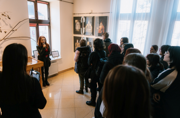 młodzież oglądająca prace na wystawie sztuki