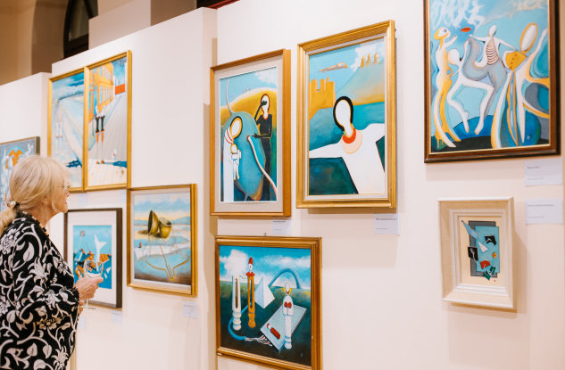kobieta ogląda obrazy w Galerii Sztuki