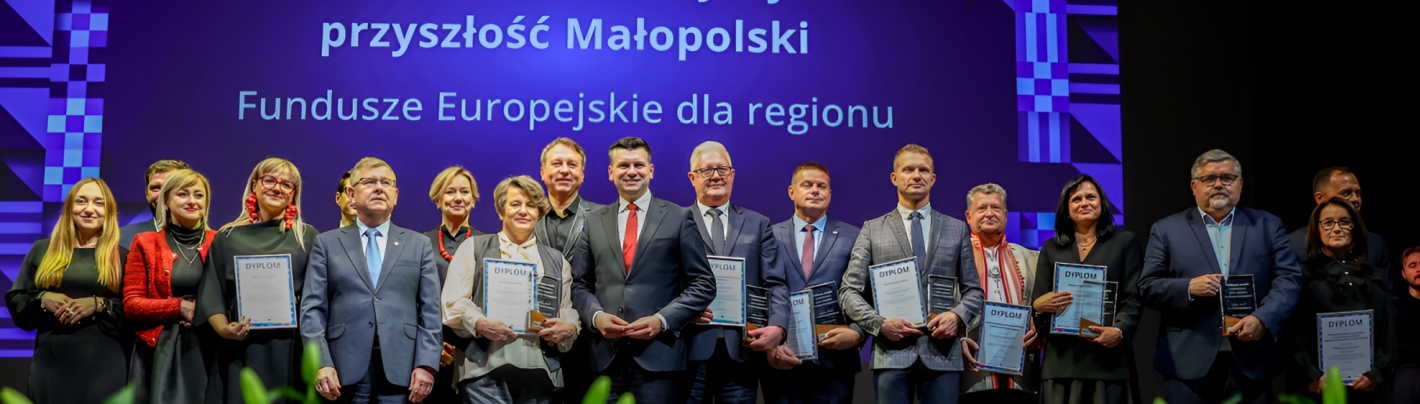 Grupa nagrodzonych ludzi pozuje do zdjęć na scenie