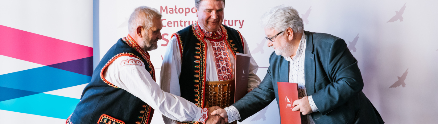 Trzech mężczyzn podających sobie dłonie