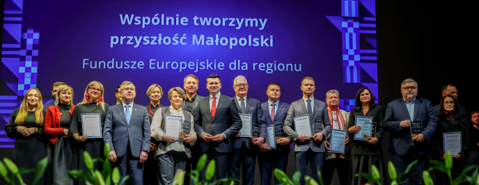 Grupa nagrodzonych ludzi pozuje do zdjęć na scenie