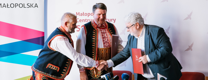 Trzech mężczyzn podających sobie dłonie
