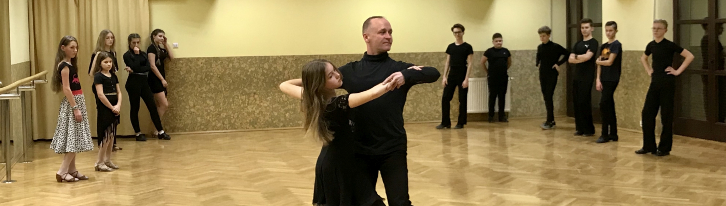 Mężczyzna tańczy z dziewczyną w sali baletowej