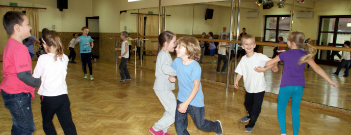 Małe dzieci tańczą w parach w sali tanecznej
